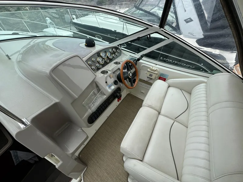 Slide: The Image of 2001 Cruisers Yachts 3470 Express helm with leather seating and wooden steering wheel. - 15