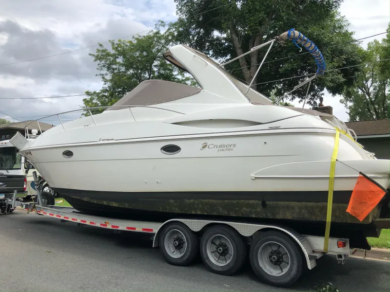 Slide: The Image of 2001 Cruisers Yachts 3470 Express on a trailer, parked on a residential street. - 2