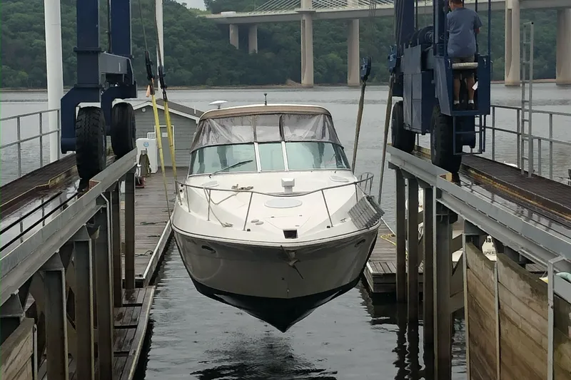 Slide: The Image of 2001 Cruisers Yachts 3470 Express being lifted at a marina dock. - 5