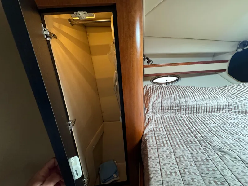 Slide: The Image of 2001 Cruisers Yachts 3470 Express cabin interior with open closet and bed. - 9