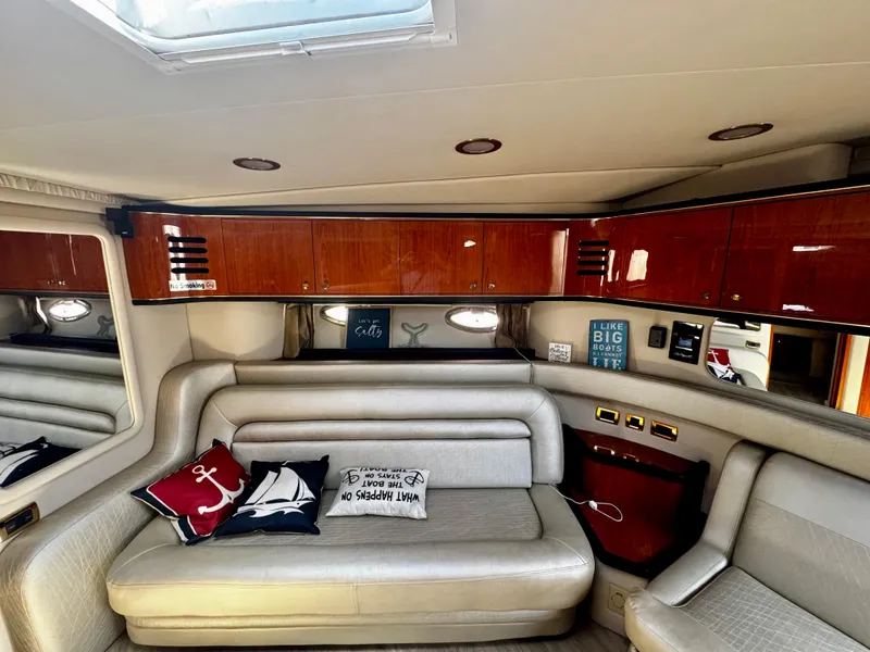 Slide: The Image of Interior of 2001 Sea Ray 460 Sundancer yacht with plush seating and nautical decor. - 12