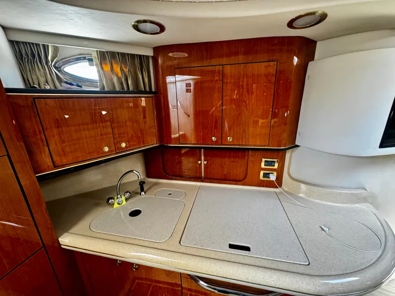 Slide: The Image of 2001 Sea Ray 460 Sundancer yacht kitchen with wood cabinets and sleek countertops. - 17