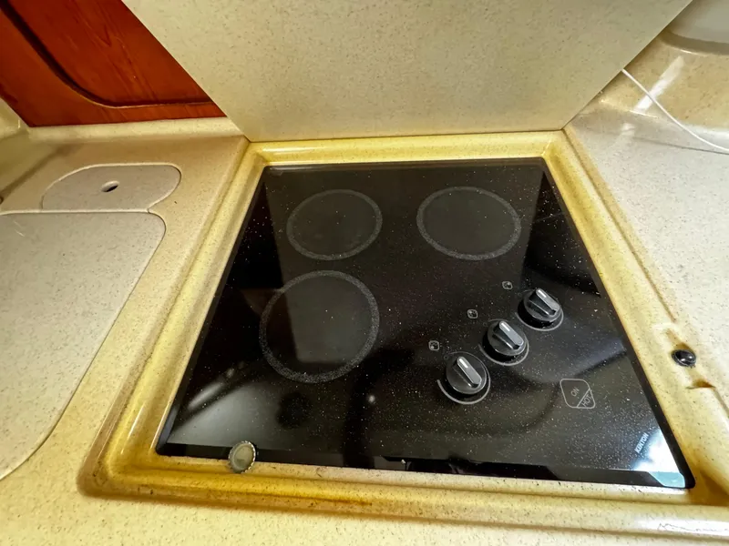Slide: The Image of Stovetop in 2001 Sea Ray 460 Sundancer yacht kitchen, featuring four burners and control knobs. - 18