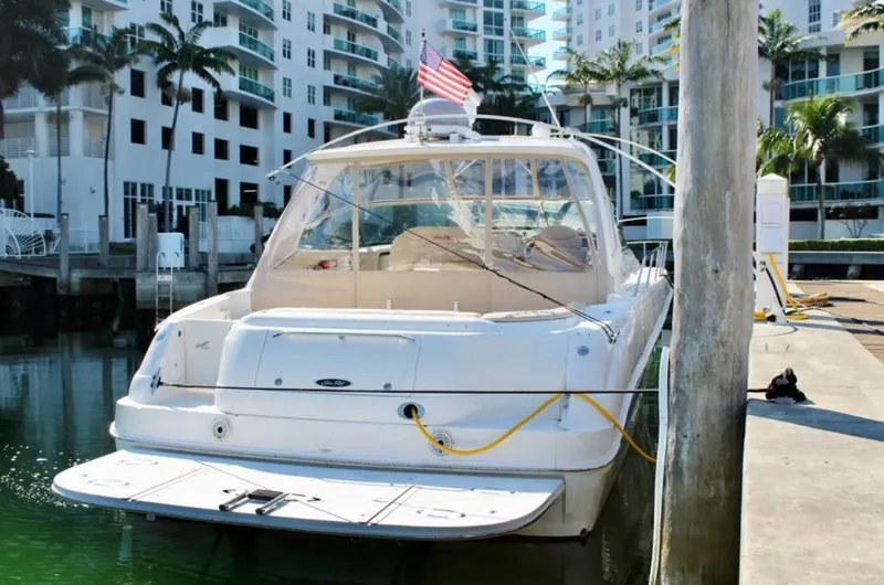 Slide: The Image of 2001 Sea Ray 460 Sundancer yacht docked in marina, with buildings and palm trees in background. - 27