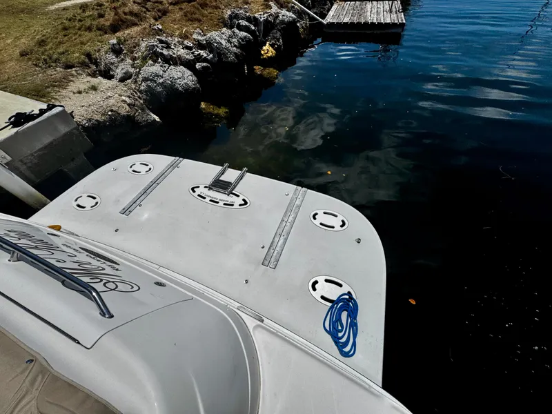 Slide: The Image of 2001 Sea Ray 460 Sundancer boat docked, showing swim platform and blue rope. - 34