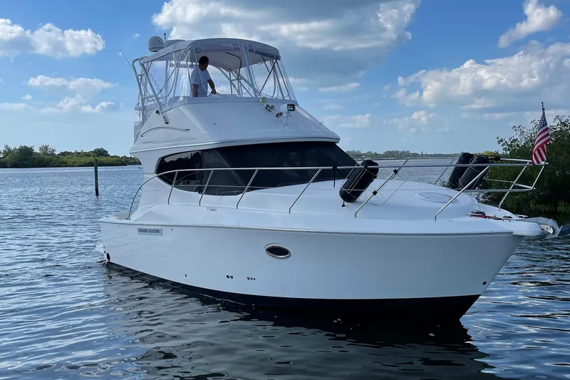 Slide: The Image of 2007 Silverton 33 Convertible yacht on calm water under a partly cloudy sky. - 3