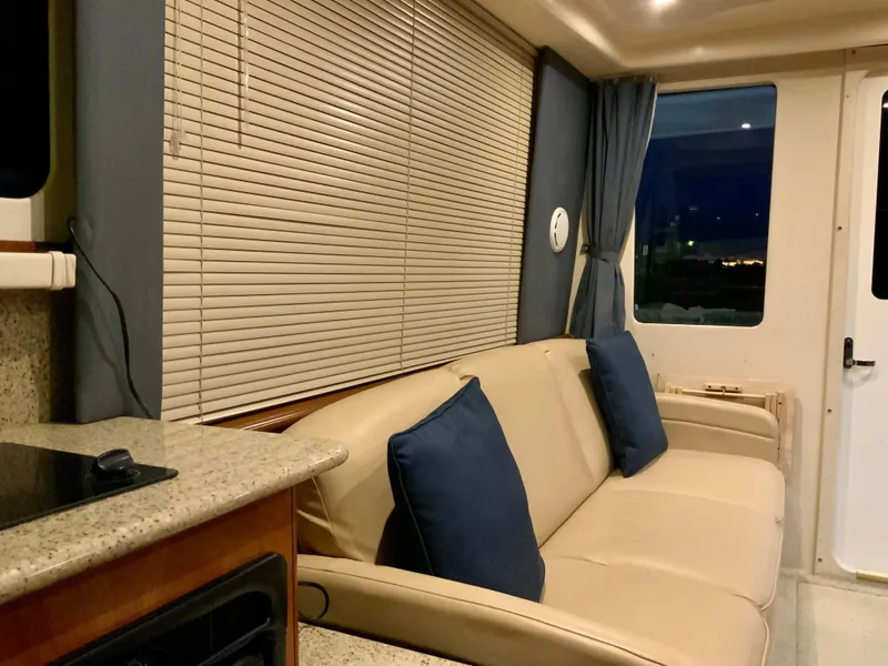 Slide: The Image of Interior of 2007 Silverton 33 Convertible yacht with beige sofa and blue cushions. - 33