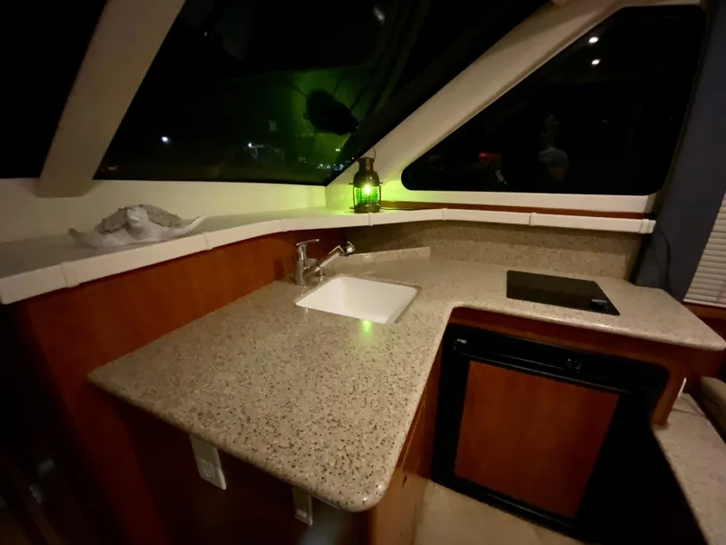 Slide: The Image of 2007 Silverton 33 Convertible yacht kitchen with sink, countertop, and window view. - 40