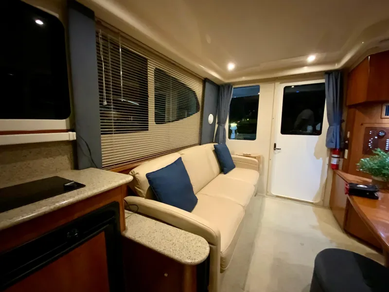 Slide: The Image of Interior of 2007 Silverton 33 Convertible yacht with beige sofa and blue cushions. - 41