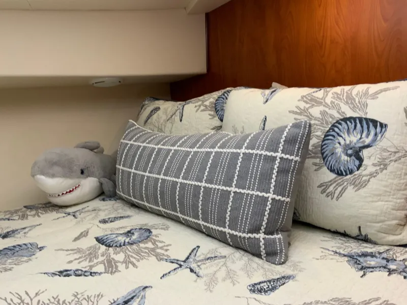 Slide: The Image of Cozy cabin bed in 2007 Silverton 33 Convertible with nautical-themed bedding and plush shark toy. - 43