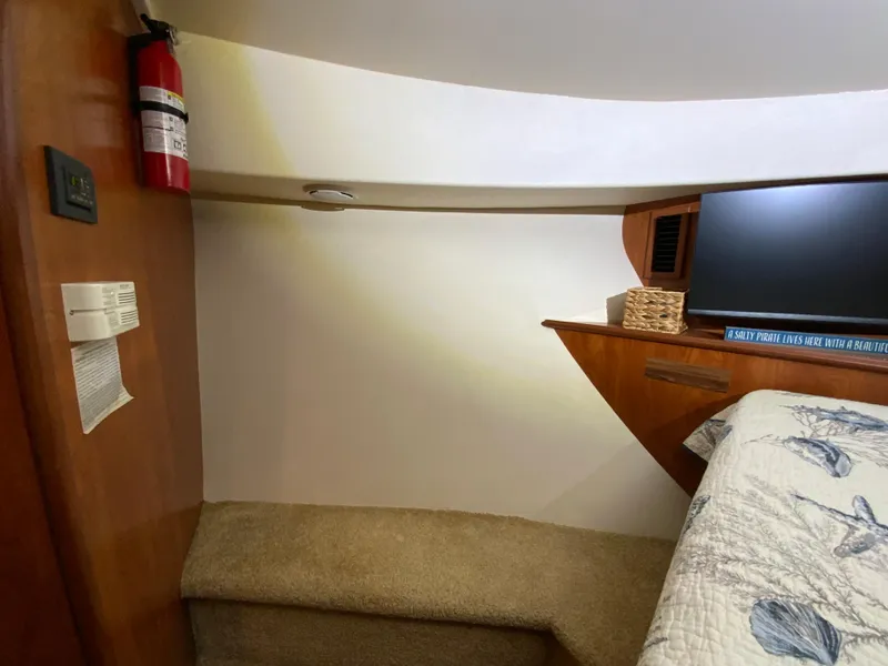 Slide: The Image of Interior of 2007 Silverton 33 Convertible boat with bed, TV, and fire extinguisher. - 46