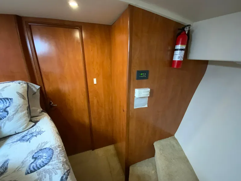 Slide: The Image of 2007 Silverton 33 Convertible interior with wood paneling, bed, and fire extinguisher. - 47