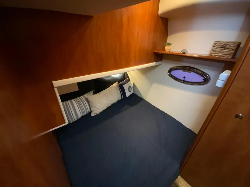 Slide: The Image of Cozy cabin interior of 2007 Silverton 33 Convertible with wooden accents and comfortable bedding. - 48