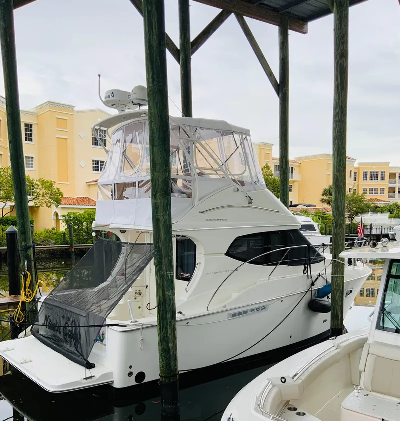 Slide: The Image of 2007 Silverton 33 Convertible yacht docked under shelter, surrounded by buildings. - 7