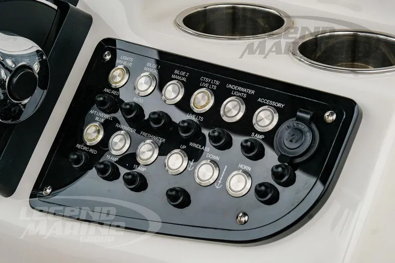 Slide: The Image of Control panel of 2022 NauticStar 2602 Legacy boat with various switches and cup holders. - 15