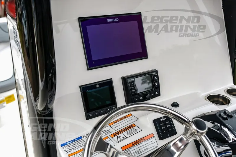 Slide: The Image of 2022 NauticStar 2602 Legacy boat dashboard with Simrad display and controls. - 17