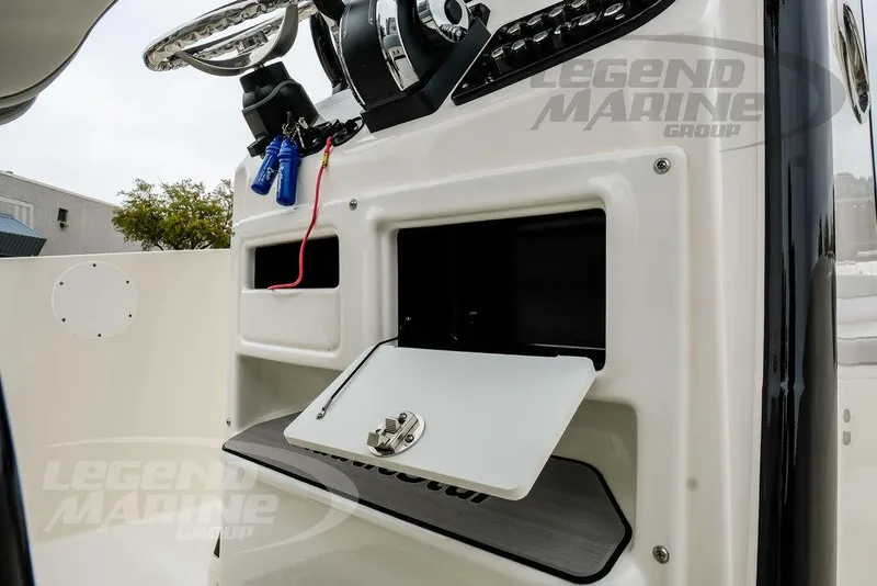 Slide: The Image of 2022 NauticStar 2602 Legacy boat console with storage compartments and steering wheel. - 21