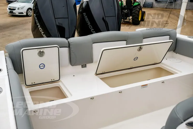 Slide: The Image of 2022 NauticStar 2602 Legacy boat with open storage compartments and dual Mercury engines. - 27