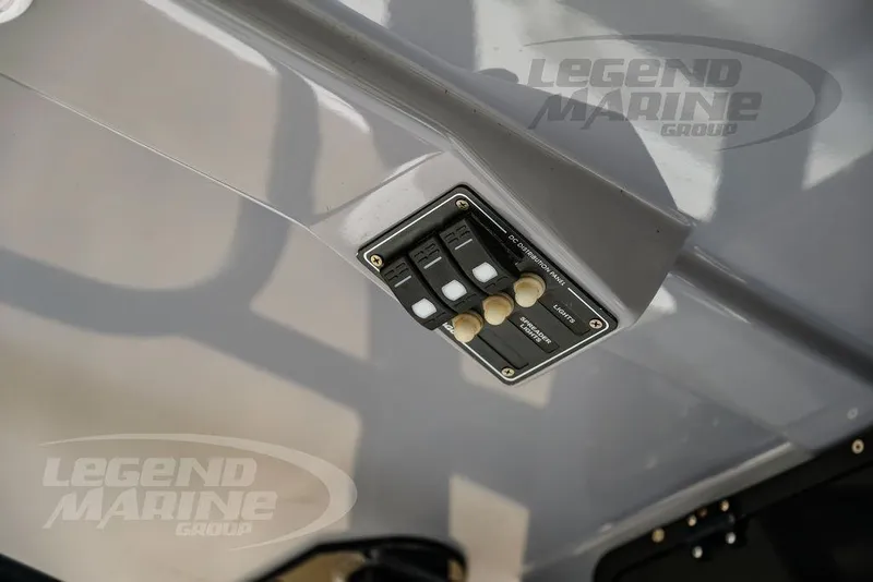 Slide: The Image of Control panel on 2022 NauticStar 2602 Legacy boat, featuring switches and Legend Marine Group branding. - 30