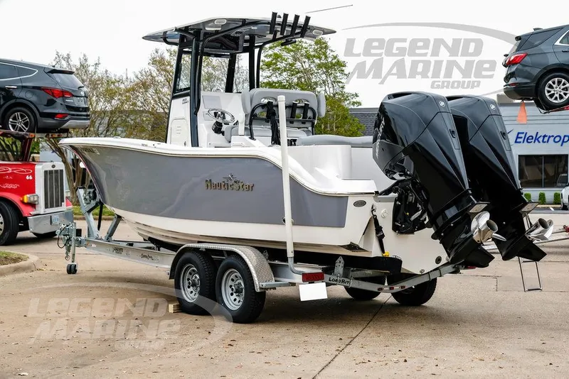 Slide: The Image of 2022 NauticStar 2602 Legacy boat on trailer with dual engines, parked outdoors. - 5