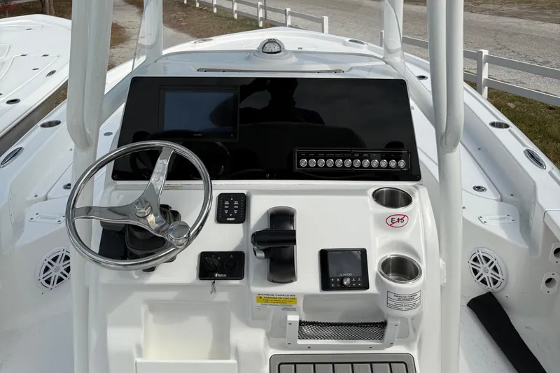 Slide: The Image of 2025 Tidewater 2210 Carolina Bay boat dashboard with steering wheel and control panel. - 12