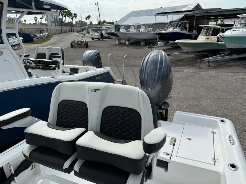 Slide: The Image of 2025 Tidewater 2210 Carolina Bay boat with dual seats and outboard motor in a marina. - 3