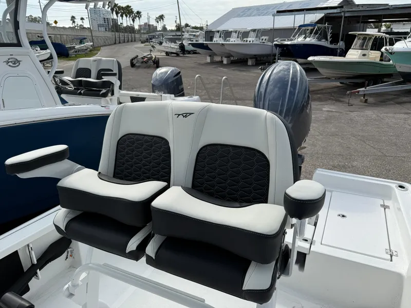 Slide: The Image of 2025 Tidewater 2210 Carolina Bay boat seats with armrests in a marina setting. - 4