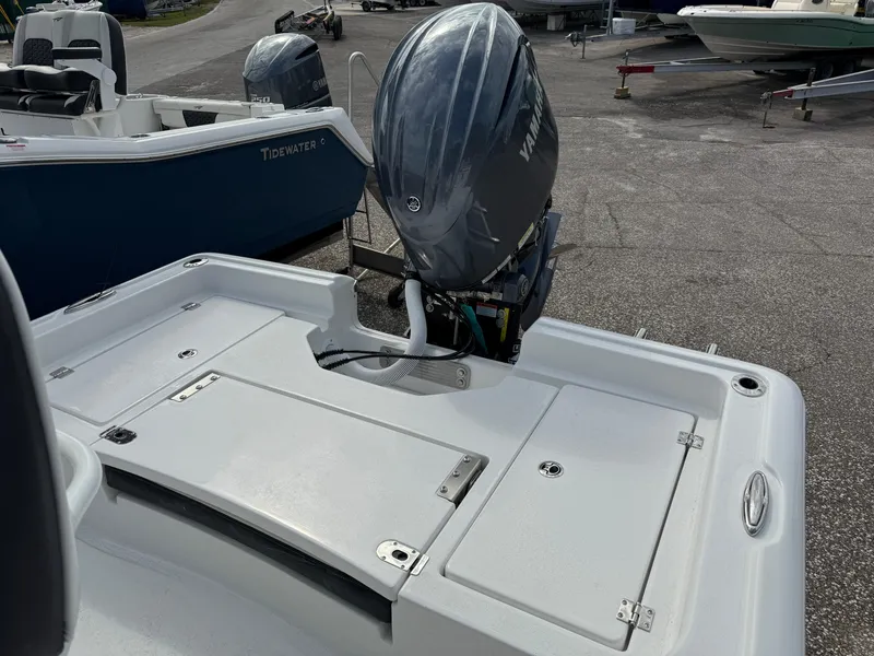 Slide: The Image of 2025 Tidewater 2210 Carolina Bay boat with outboard motor in a marina setting. - 5
