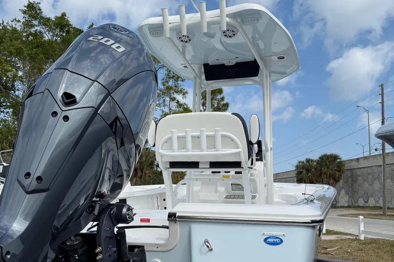 Slide: The Image of 2025 Tidewater 2210 Carolina Bay boat with powerful outboard motor, parked outdoors. - 8