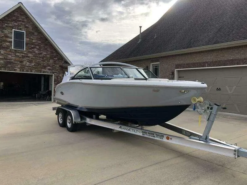 Slide: The Image of 2022 Cobalt CS22 boat on trailer parked in driveway near brick house. - 1