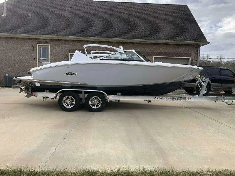 Slide: The Image of 2022 Cobalt CS22 boat on trailer, parked in driveway, side view. - 2