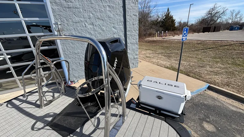 Slide: The Image of 2025 Balise Helix 24C boat with outboard motor, parked near a modern building. - 26