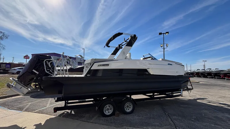 Slide: The Image of 2025 Balise Helix 24C boat on trailer outside dealership under clear sky. - 29