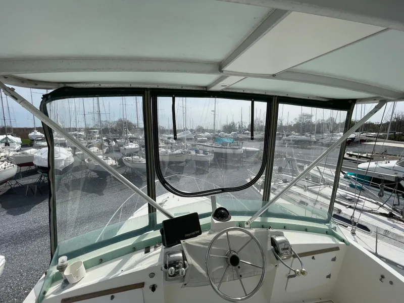 Slide: The Image of 1978 Bertram 33 Flybridge Cruiser helm with marina view. - 11