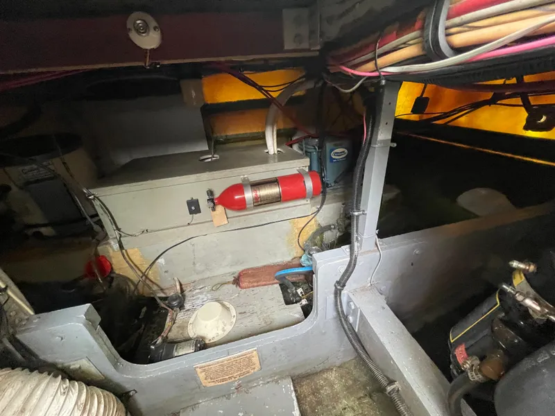 Slide: The Image of Engine room of a 1978 Bertram 33 Flybridge Cruiser with visible fire extinguisher and wiring. - 15
