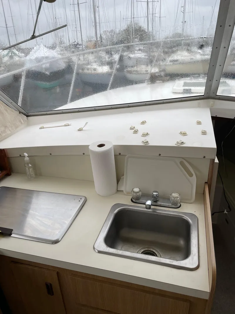 Slide: The Image of 1978 Bertram 33 Flybridge Cruiser kitchen area with sink, cutting board, and paper towel. - 19