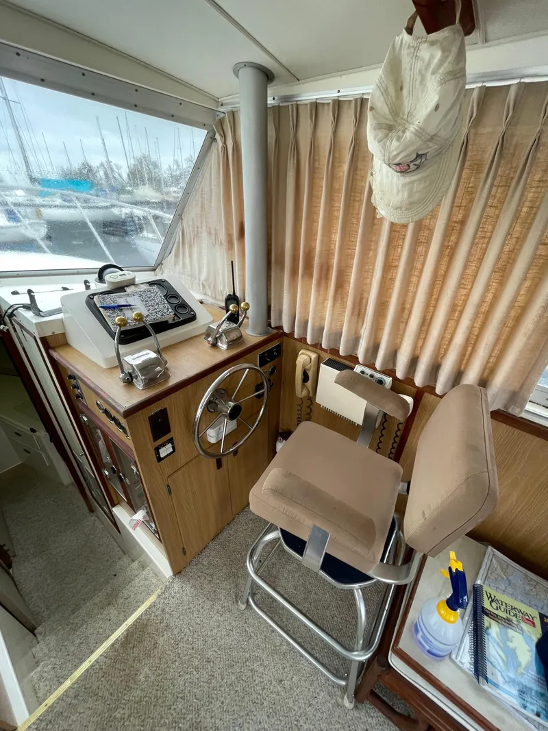 Slide: The Image of 1978 Bertram 33 Flybridge Cruiser helm with steering wheel, controls, and nautical decor. - 21