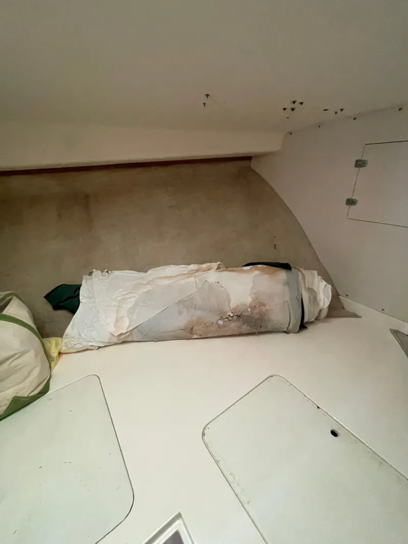 Slide: The Image of Interior of a 1978 Bertram 33 Flybridge Cruiser with storage area and rolled-up sail. - 23