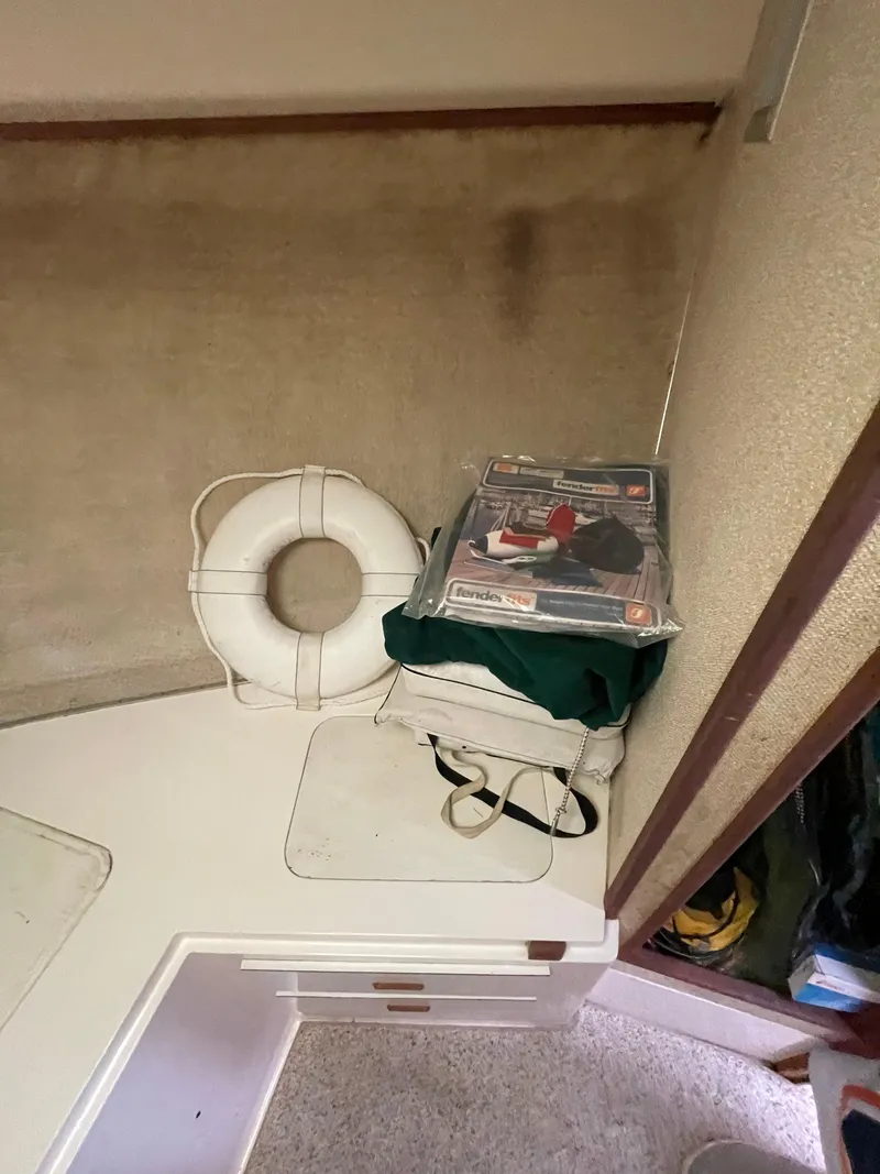 Slide: The Image of 1978 Bertram 33 Flybridge Cruiser interior with life preserver and storage items. - 25