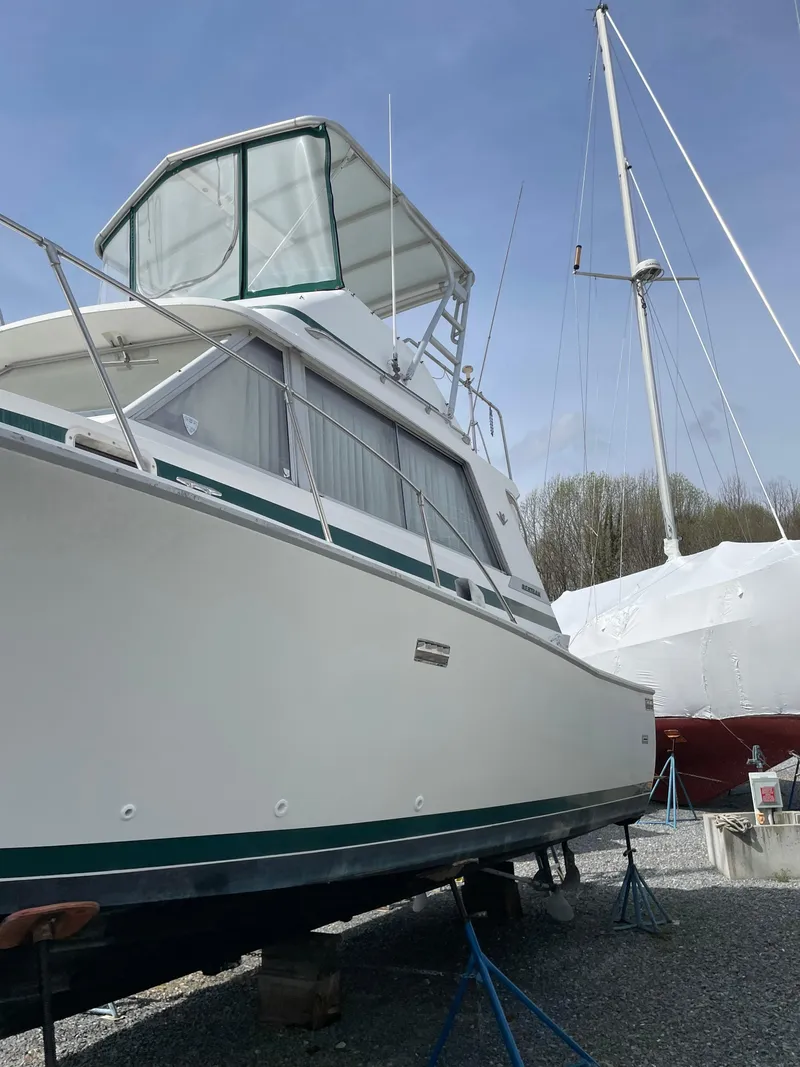Slide: The Image of 1978 Bertram 33 Flybridge Cruiser on dry dock, with clear sky background. - 4