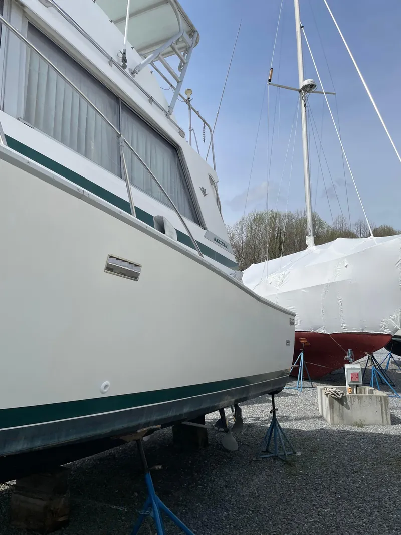 Slide: The Image of 1978 Bertram 33 Flybridge Cruiser on stands, side view, with another boat nearby. - 5
