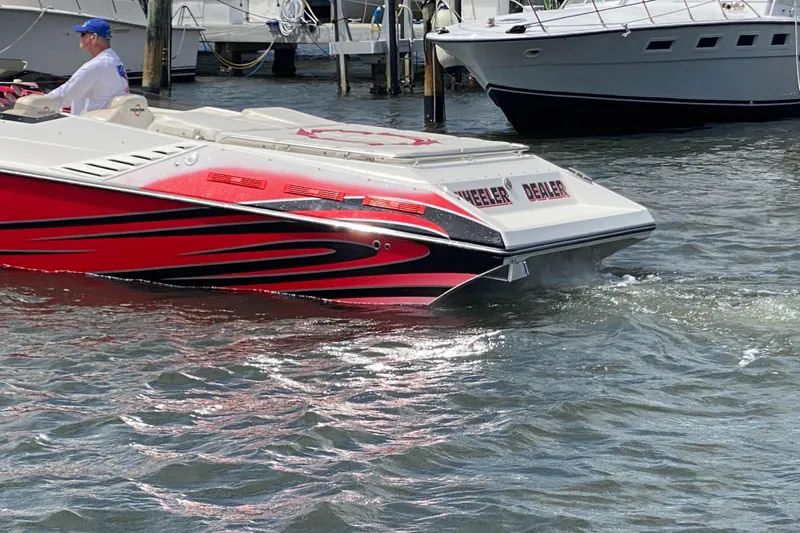 Slide: The Image of 2006 Fountain 42 Executioner speedboat with red and black design on the water. - 2