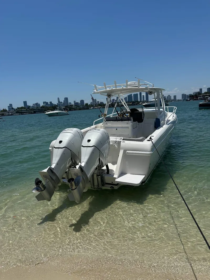 Slide: The Image of 2005 Intrepid 355 boat with dual engines anchored on a sunny beach. - 1