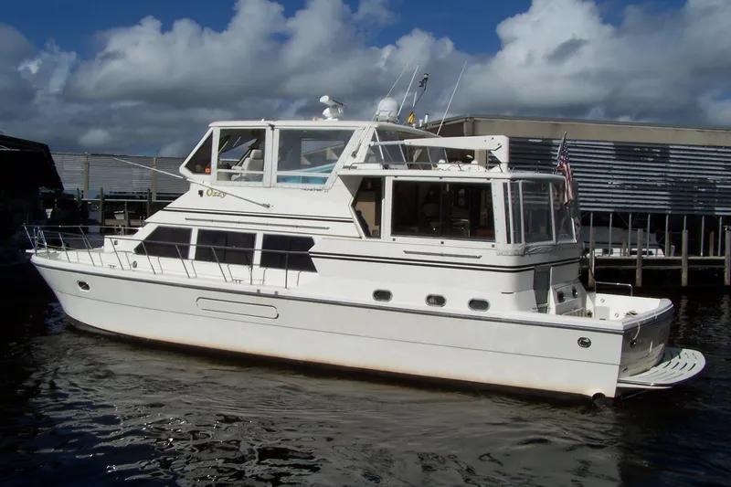Slide: The Image of 2004 Novatec Islander CPMY yacht docked, featuring a sleek white design under a cloudy sky. - 13