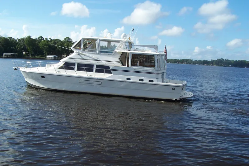 Slide: The Image of 2004 Novatec Islander CPMY yacht cruising on a calm lake under a clear blue sky. - 17