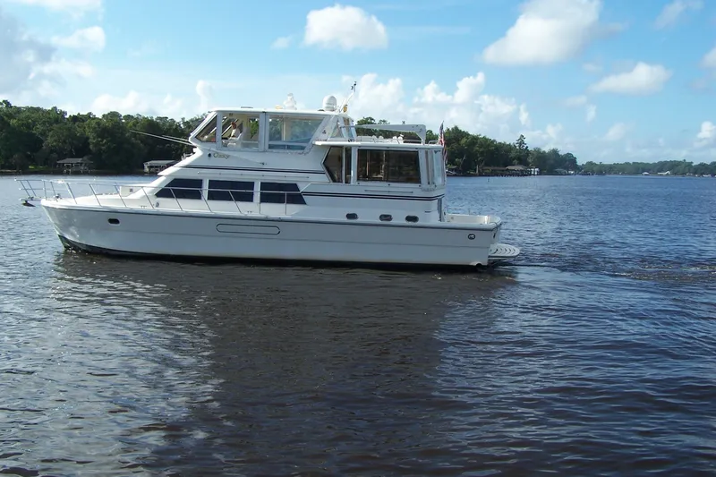 Slide: The Image of 2004 Novatec Islander CPMY yacht cruising on a calm lake under a blue sky. - 18