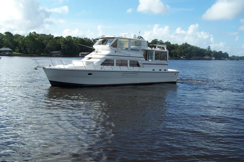 Slide: The Image of 2004 Novatec Islander CPMY yacht cruising on a serene lake under a blue sky. - 20