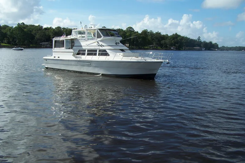 Slide: The Image of 2004 Novatec Islander CPMY yacht on a serene lake with lush green shoreline. - 21