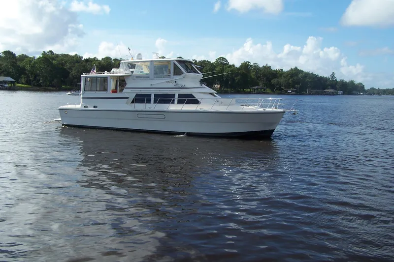 Slide: The Image of 2004 Novatec Islander CPMY yacht on a calm river with lush green shoreline. - 22