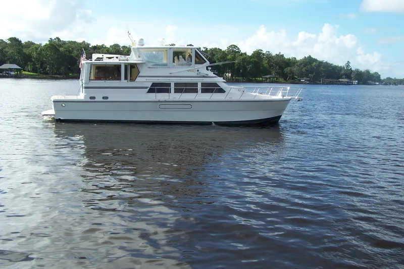 Slide: The Image of 2004 Novatec Islander CPMY yacht on a serene lake with lush green shoreline. - 23